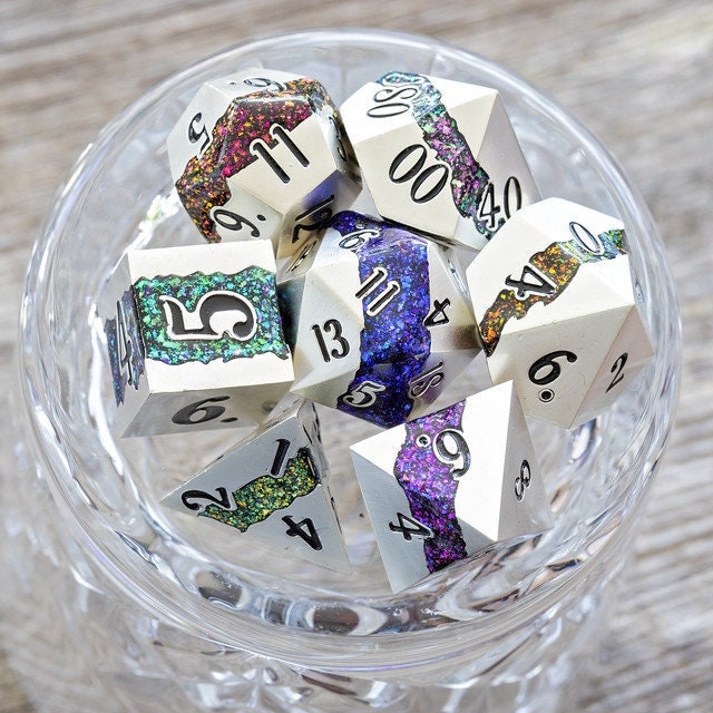 Cool seven piece metal polyhedral dnd dice set in silver metal with beautiful stripes of glittery rainbow resin.