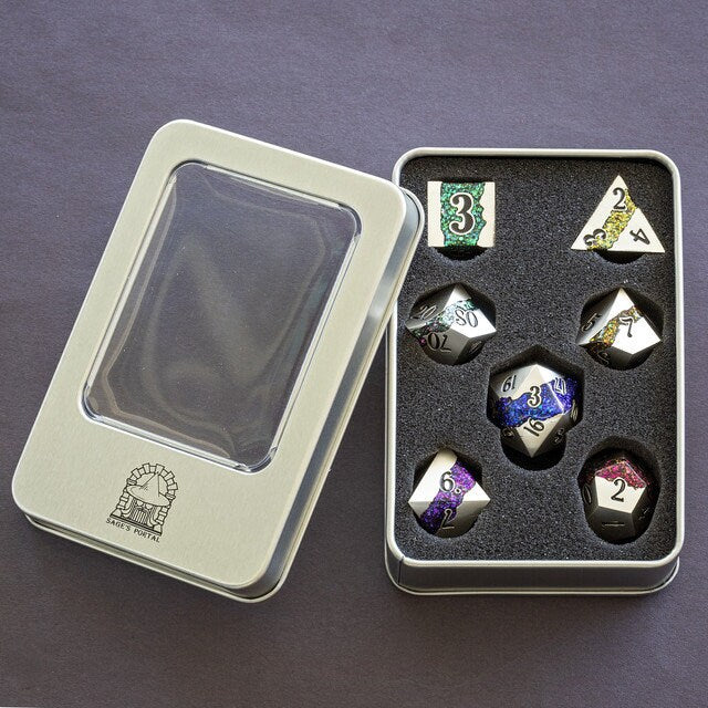 Cool seven piece metal polyhedral dnd dice set in silver metal with beautiful stripes of glittery rainbow resin inside of a metal dice box.